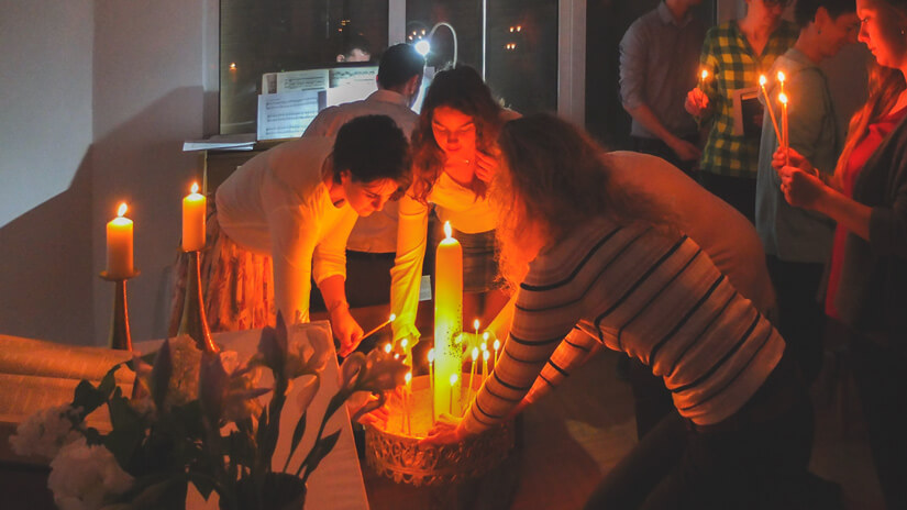 Gemeindemitglieder zünden Kerzen an